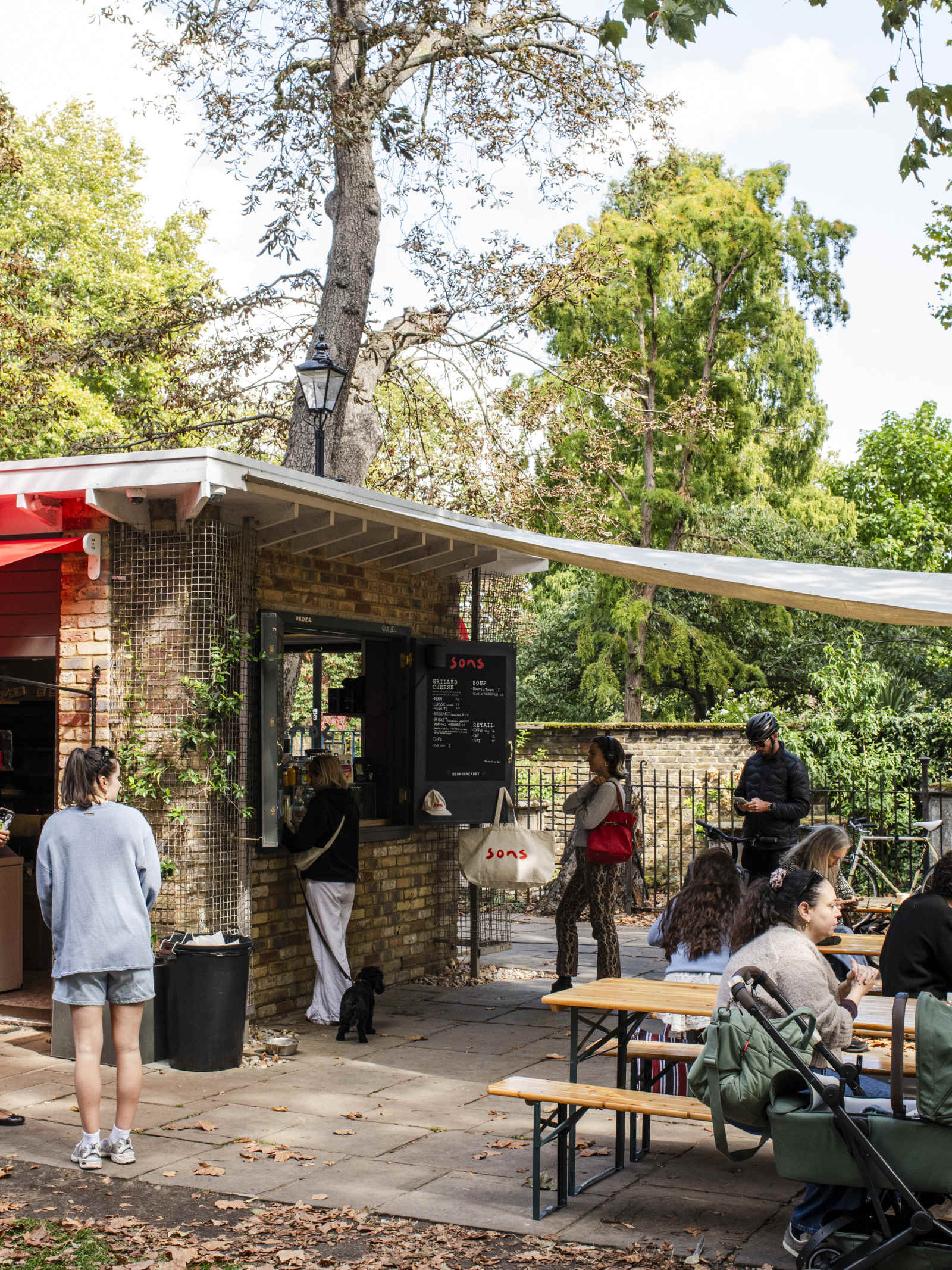 People sitting at outdoor tables in the Sons Coffee courtyard at St John at Hackney