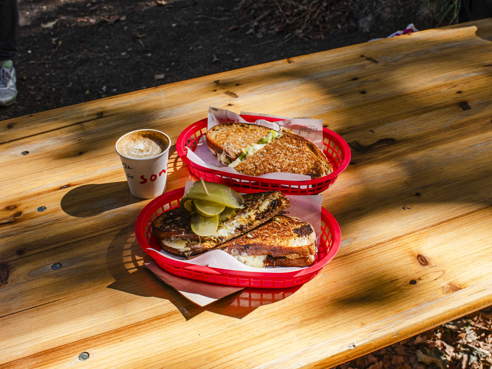 Toasties and coffee on a wooden picnic table at Sons Coffee